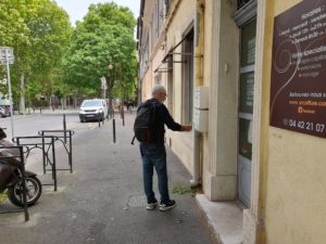 Distribution d'imprimés publicitaire sur Aix-en-Provence distributeur en train de mettre dans une boite dans une rue du centre ville