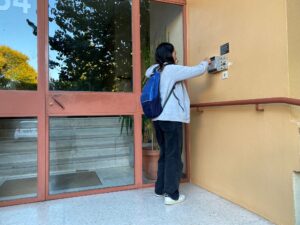 distribution flyers à Aubagne hôtesse en train d'entrer dans un immeuble pour distribuer en boites aux lettres