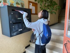 distribution flyers à Aubagne, hôtesse en train de distribuer un cedex de boites aux lettres dans un hall d'entrée