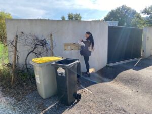 Distribution boites aux lettres pour les Mairies hôtesse en train de mettre un document dans une boites d'une villa  Bouc Bel Air