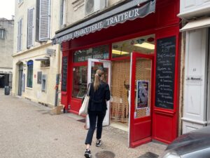 Hôtesse entrant dans une boucherie d'Arles