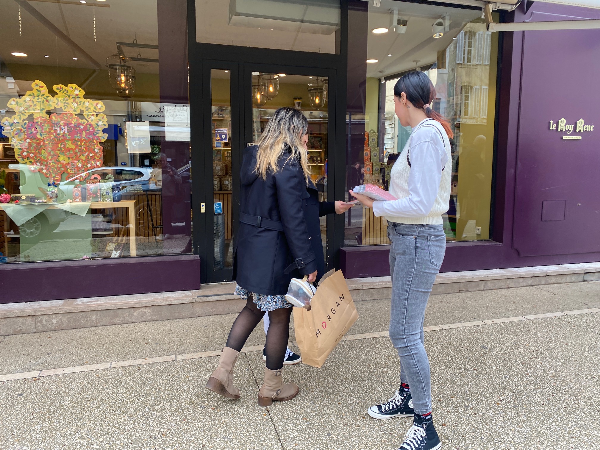 photo street salon centre ville, une hôtesse distribue mais à mains