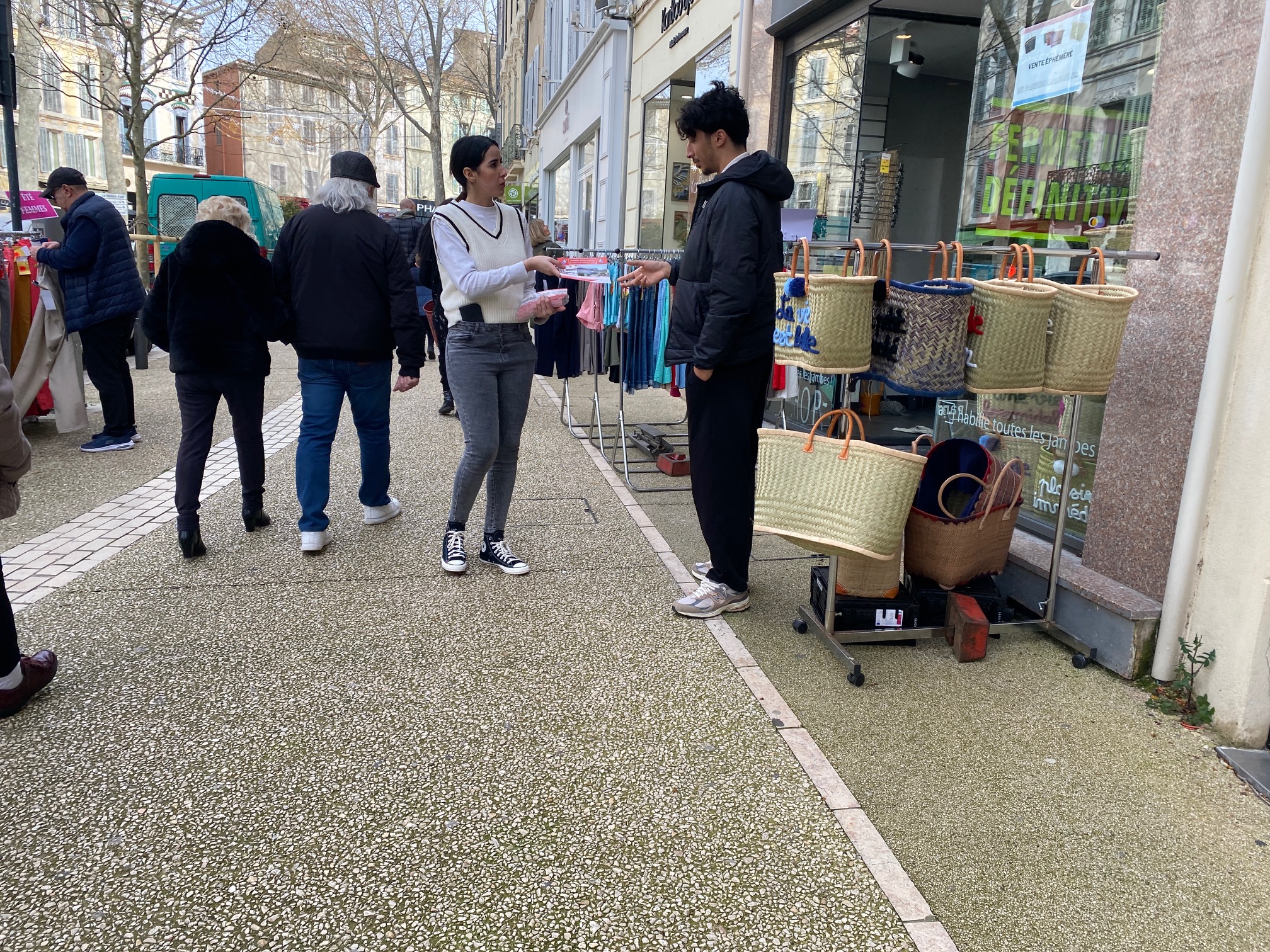 photo street salon centre ville, une hôtesse distribue mais à mains